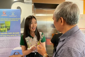 Phạm Ngọc Hà giới thiệu sản phẩm bột dinh dưỡng từ bèo tấm với khách tham quan. Ảnh: Hà An