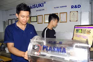 Sinh viên do PGS.TS Trần Ngọc Đảm hướng dẫn thực hành trên mô hình sử dụng công nghệ plasma. Ảnh: Hà An