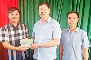 Thầy Khương Văn Hưng (giữa) trao số tiền ủng hộ người dân cho đại diện địa phương xã Quỹ Nhất, Ninh Bình.