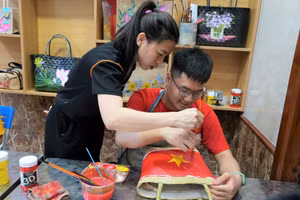 Cô giáo hướng dẫn trẻ vẽ tranh lên túi cói. Ảnh: Hồ Lài 