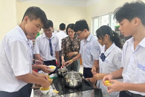 Cô Ngô Thị Hồng Ngọc hướng dẫn học sinh chuẩn bị các món ăn. Ảnh: MA