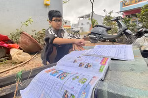 Ngô Tấn Phú - học sinh lớp 5B, Trường Tiểu học số 1 Nhơn Bình (phường Quy Nhơn Đông, tỉnh Gia Lai) phơi những cuốn vở ướt sũng nước. Ảnh: Dung Nguyễn