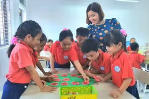 Giáo viên Trường Tiểu học thị trấn Rạng Đông (Ninh Bình) hướng dẫn học sinh thực hành làm sản phẩm STEM “Cây gia đình”. Ảnh: NTCC