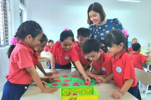 Giáo viên Trường Tiểu học thị trấn Rạng Đông (Ninh Bình) hướng dẫn học sinh thực hành làm sản phẩm STEM “Cây gia đình”. Ảnh: NTCC
