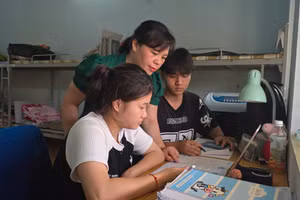 Chị Lò Thị Liên, Trưởng phòng Quản lý, Chăm sóc, Nuôi dưỡng trẻ em và người cao tuổi chăm sóc 2 thí sinh trước Kỳ thi tốt nghiệp THPT năm 2025. Ảnh: PV