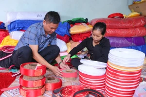 Người dân làng nghề Giáp Nhất (Nam Trực, Ninh Bình) tỉ mỉ hoàn thiện sản phẩm khăn xếp truyền thống.