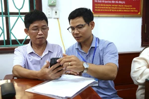 Cán bộ xã Ý Yên hướng dẫn người dân sử dụng dịch vụ công trực tuyến.