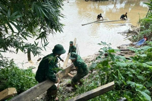 Cán bộ BĐBP Điện Biên vớt khung, cột nhà của người dân còn sót lại sau trận lũ quét vừa qua. (Ảnh: Đồn Biên phòng Mường Pồn)