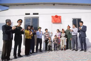 Đại biểu và người dân cùng kéo biển khánh thành nhà ở mới. 