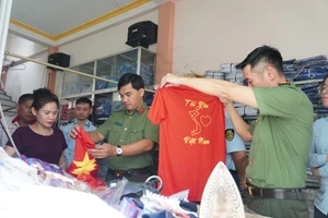 Nhiều chiếc áo phông in bản đồ Việt Nam thiếu Hoàng Sa, Trường Sa bị thu giữ tại cơ sở kinh doanh thời trang của ông Dư Công Nghiệp. (Ảnh: Công an Điện Biên)