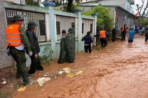 Cán bộ, chiến sĩ và lực lượng dân quân hỗ trợ người dân di tản.