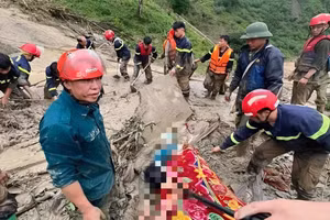 Lực lượng cứu hộ nỗ lực đưa thi thể nạn nhân trong vụ lũ quét ra khỏi đống đất đá. 