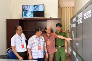 Ông Vừ A Bằng (thứ 2 bên trái) kiểm tra phòng bảo quản đề thi tại điểm thi Trường THPT thành phố Điện Biên Phủ.