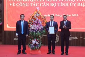 Ông Phan Thăng An (trái) tặng hoa và trao quyết định điều động, chỉ định của Ban Chấp hành Trung ương Đảng cho ông Trần Tiến Dũng (đứng giữa).