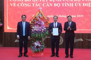 Ông Phan Thăng An (trái) tặng hoa và trao quyết định điều động, chỉ định của Ban Chấp hành Trung ương Đảng cho ông Trần Tiến Dũng (đứng giữa).