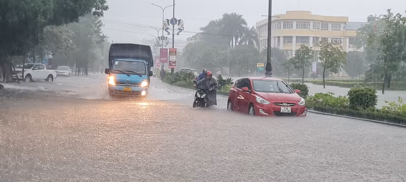 Một số phương tiện giao thông vẫn cố băng qua đoạn đường ngập lụt. Quảng Bình mưa như trút nước, đường phố 'tê liệt'