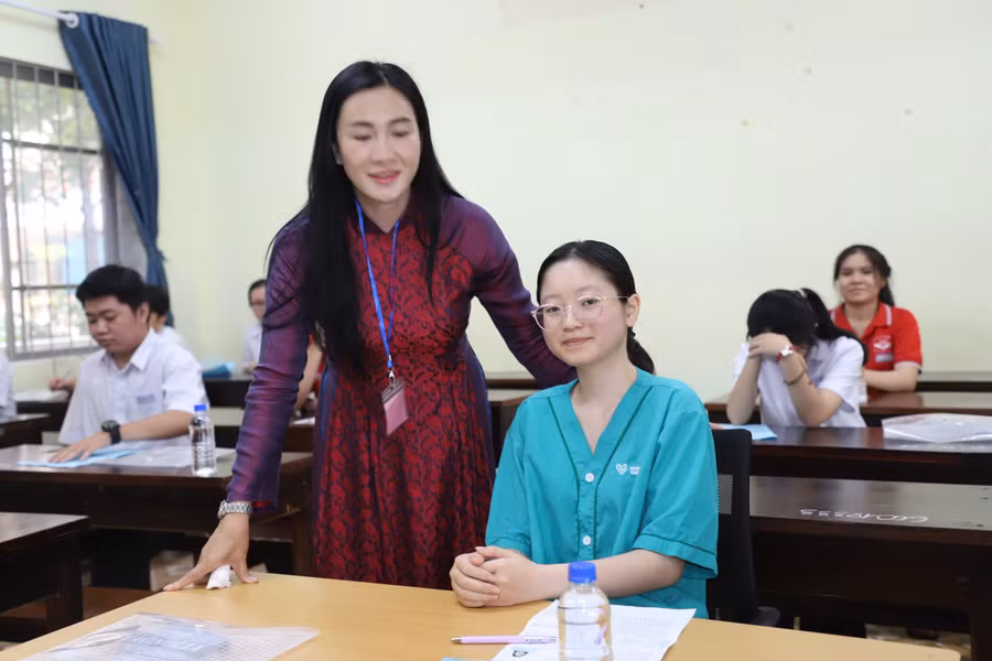 Lãnh đạo Điểm thi Trường THPT Buôn Ma Thuột động viên Huyền Trân trước giờ làm bài môn Ngữ văn. (Ảnh: TT)
