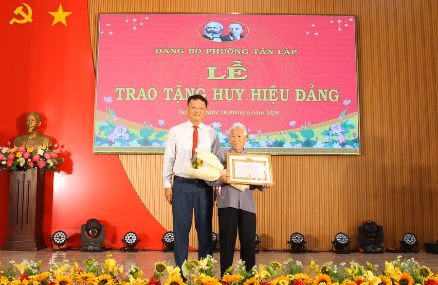 Ông Vũ Văn Hưng trao Huy hiệu 65 năm tuổi Đảng cho cụ Hồ Phi Thức. (Ảnh: Thành Tâm)