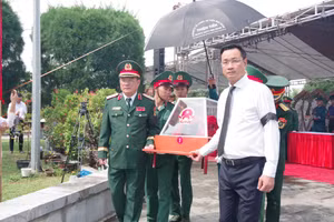 Ông Lê Ngọc Quang (áo trắng), Bí thư Thành ủy Đà Nẵng đưa các hài cốt liệt sĩ đi an táng. Ảnh: Quang Cường, Bộ CHQS Đà Nẵng