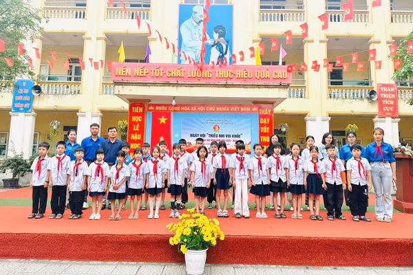 Lãnh đạo nhà trường chụp ảnh cùng học sinh trong buổi hoạt động ngoại khóa.