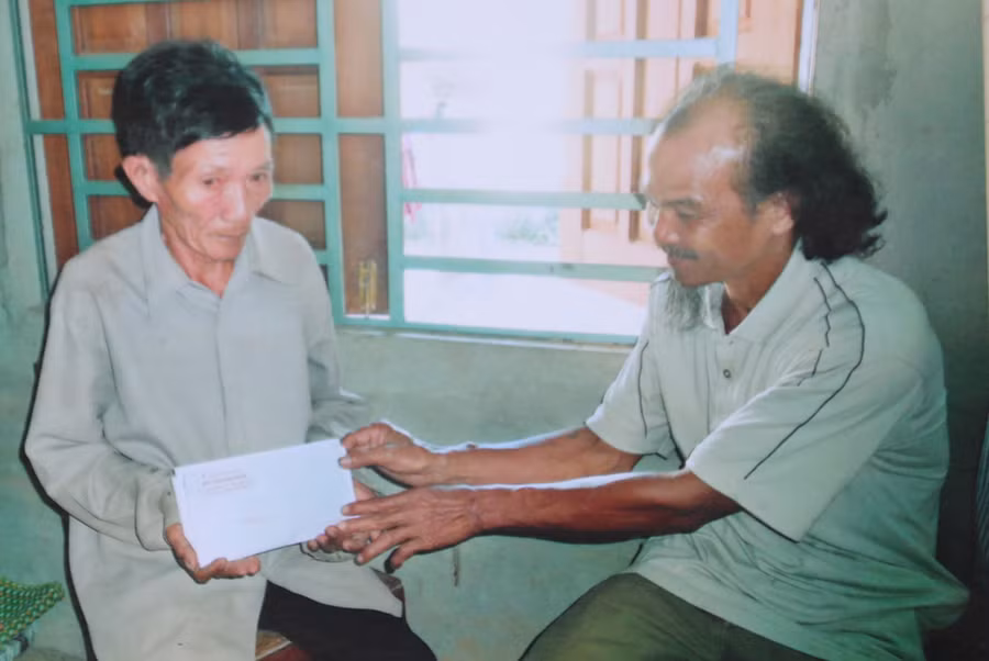 Ông Bình hỗ trợ tiền cho một người nghèo