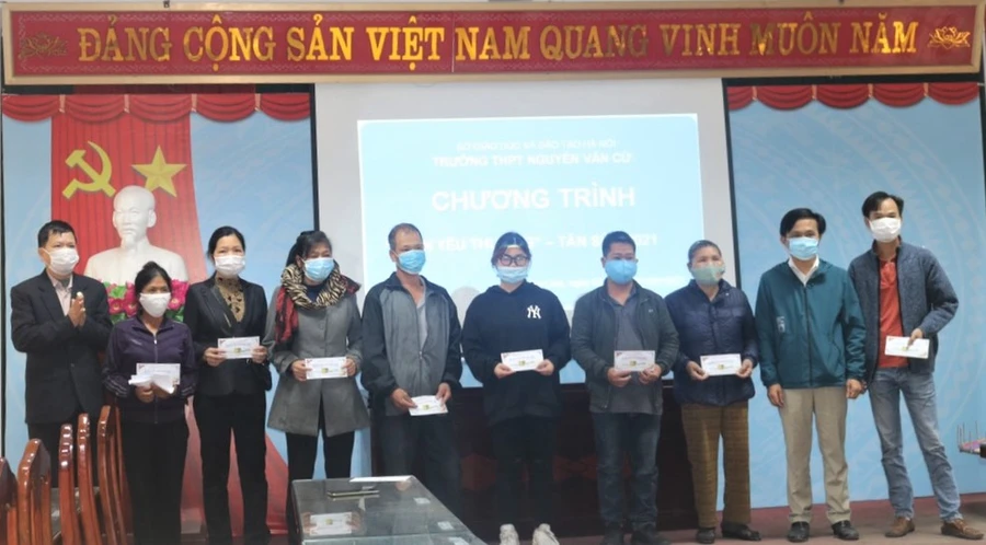 Đại diện gia đình học sinh có hoàn cảnh khó khăn lên nhận hỗ trợ.