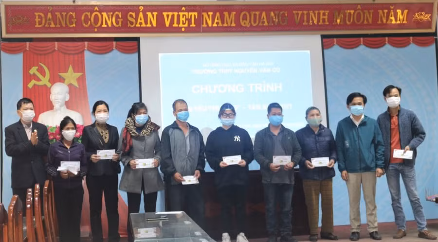 Đại diện gia đình học sinh có hoàn cảnh khó khăn lên nhận hỗ trợ.