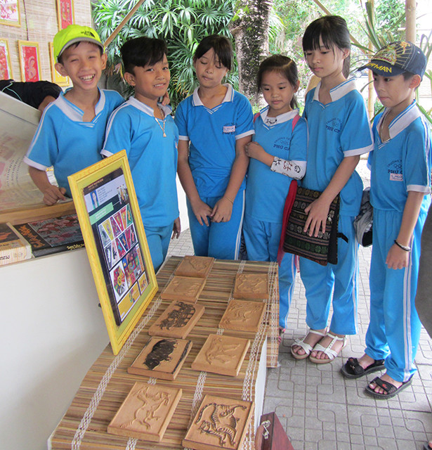 Các em HS đến tham quan cơ sở, xem tranh làng Sình của ông Phước