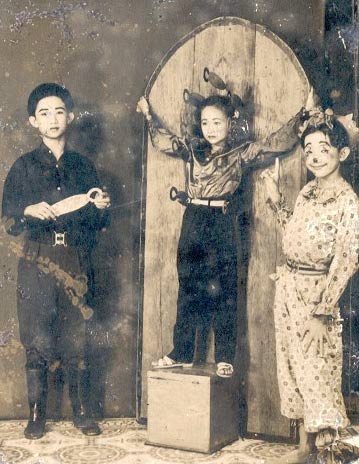 Mạc Can thuở nhỏ (bìa phải) cùng anh trai và em gái trong màn xiếc phóng dao. Mạc Can thuở nhỏ (bìa phải) cùng anh trai và em gái trong màn xiếc phóng dao.