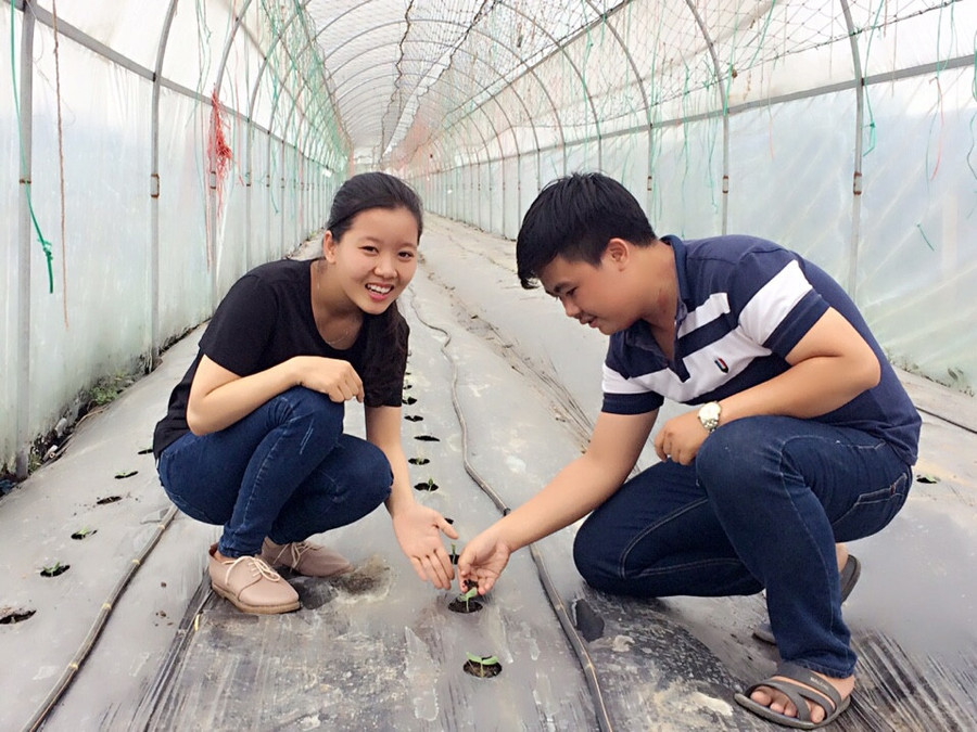 Hai bạn Hồng Mức và Huy Hào bên vườn rau sử dụng sản phẩm bùn vi sinh