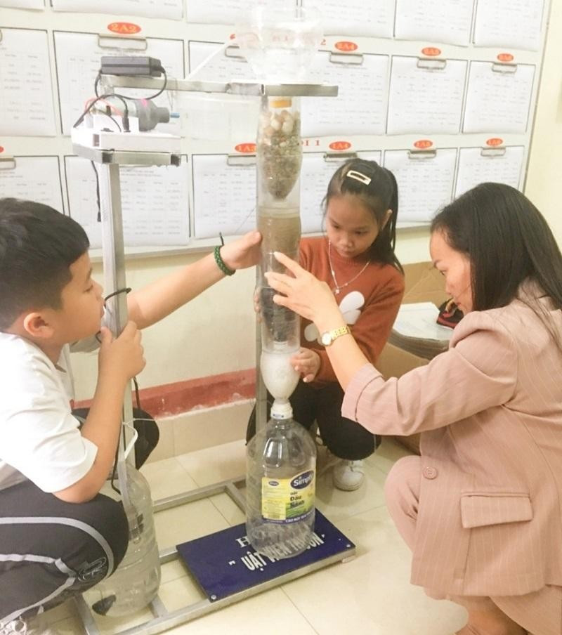 Cô Thơm cùng học sinh nghiên cứu làm máy lọc nước. Ảnh NVCC. Mở lòng của cô giáo về chuyện dạy lớp học xóa mù chữ ảnh 1