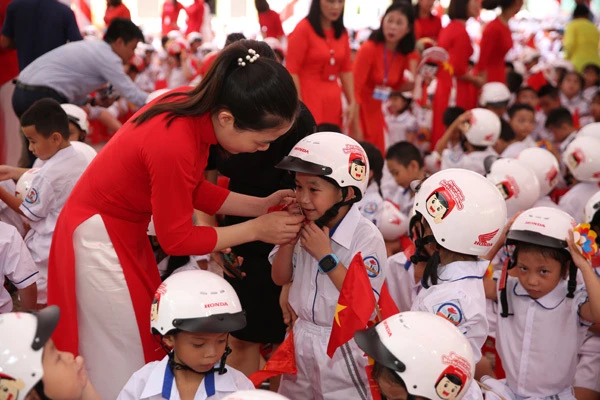 Hướng dẫn học sinh đội mũ bảo hiểm theo qui định.