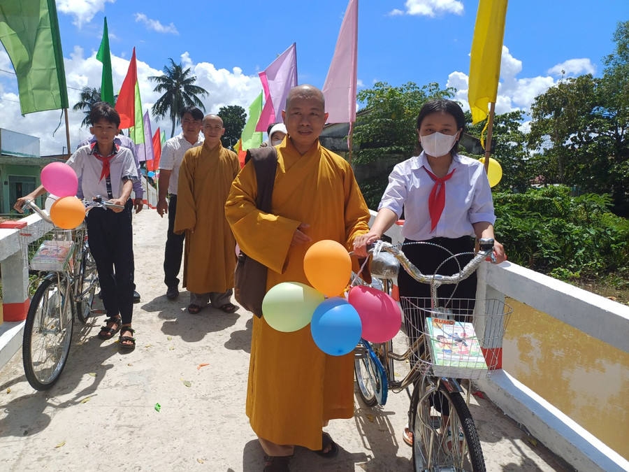 Trong lễ khánh thành cầu Đại đức Thích Mật Tịnh tặng xe đạp cho học sinh.
