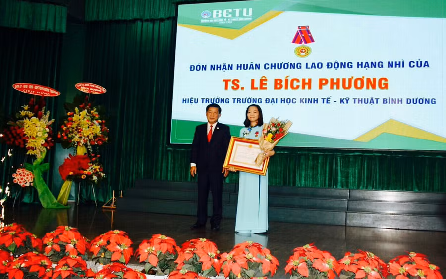 Ông Trần Thanh Liêm, Phó Bí thư Tỉnh ủy, Chủ tịch UBND tỉnh trao Huân chương Lao động hạng Nhì cho TS. Lê Bích Phương – Hiệu trưởng nhà trường