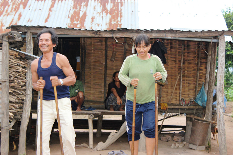 Trưởng thôn Đinh Yao và Đinh Thị Lên dùng cà kheo đi gọi từng nhà tập luyện