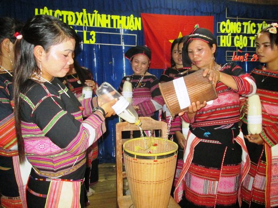 Chị em phụ nữ Bana xã Vĩnh Thuận trong một buổi sinh hoạt chia gạo