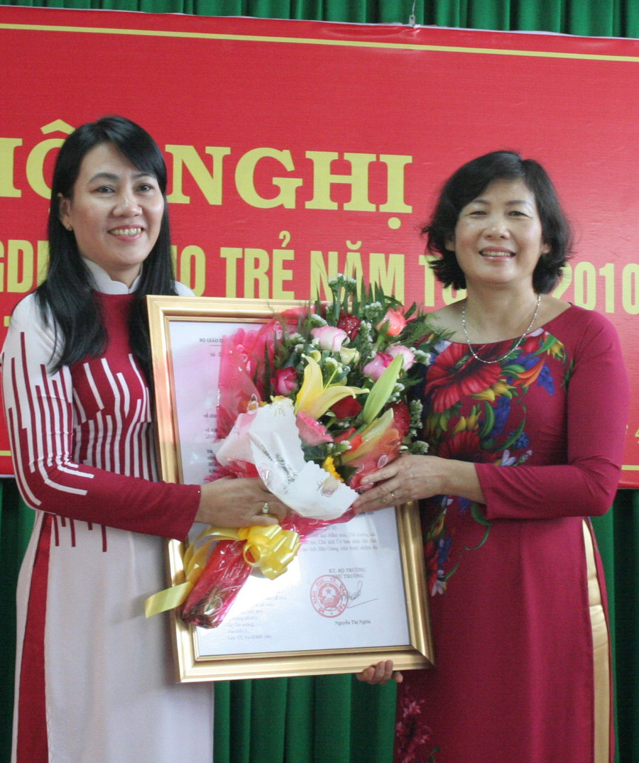 Bà Nguyễn Hoài Thúy Hằng (trái) - Giám đốc Sở GD&ĐT Hậu Giang đón nhận bằng công nhận đạt chuẩn PC GDMN cho trẻ 5 tuổi