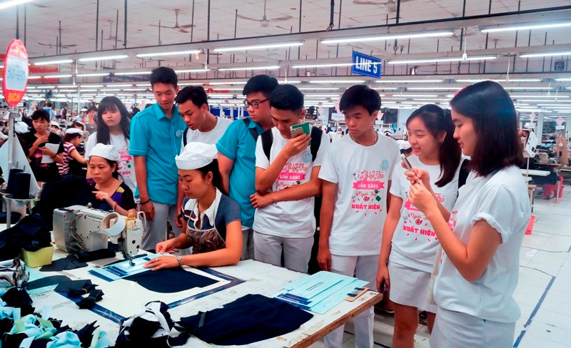 Một nhóm HS tham quan, trải nghiệm ở nhà máy dệt trong chương trình hướng nghiệp của nhóm Vút bay