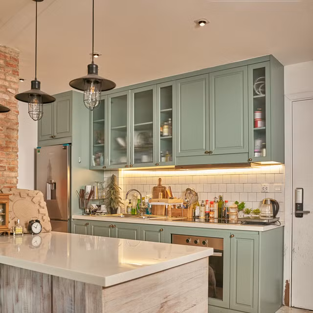 Không gian bếp nổi bật với hệ thống tủ màu xanh.