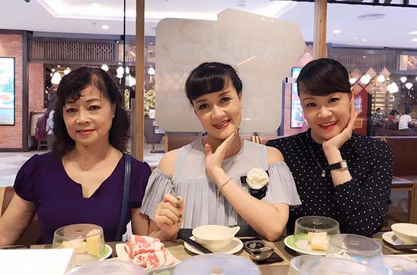 Hai chị em chụp hình cùng mẹ.