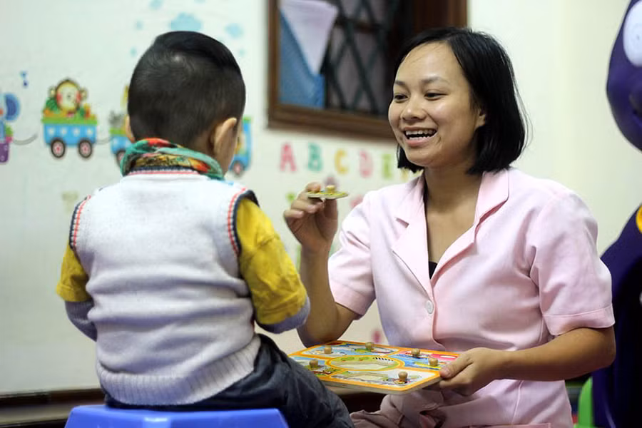 Một giáo viên đang hướng dẫn trẻ bị rối loạn đọc