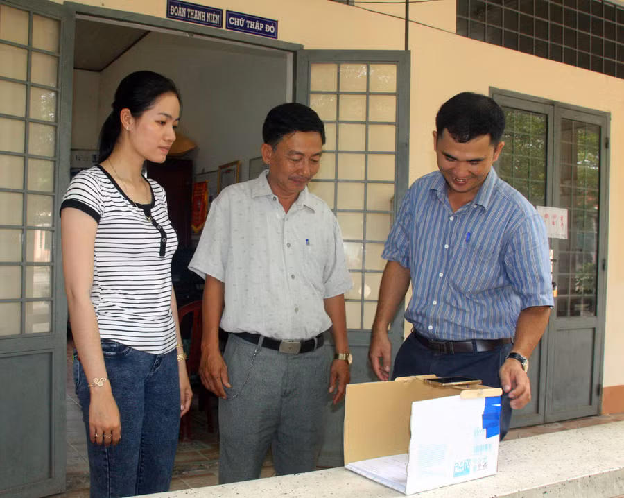 Thầy Cường (phải) hướng dẫn các giáo viên chấm thi trắc nghiệm bằng điện thoại