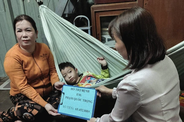 Đại diện nhà trường trao chuyển tiền các nhà hảo tâm ủng hộ bé Phạm Quốc Trọng. 