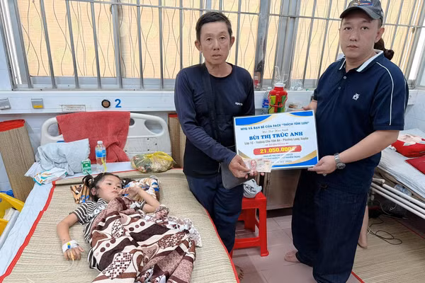 Đại diện các nhà hảo tâm trao tiền ủng hộ nữ sinh Bùi Thị Trúc Anh.