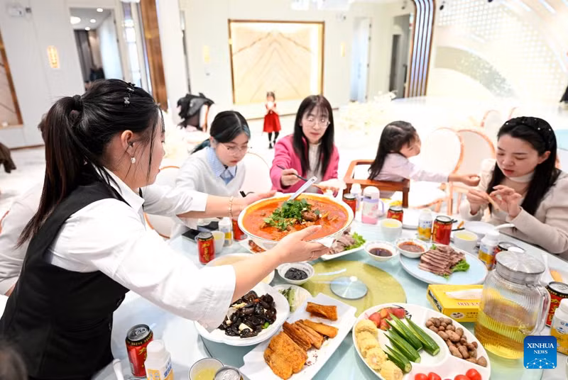 Nhân viên phục vụ món đặc sản địa phương cho khách tại nhà hàng ở huyện Yanchi, thành phố Ngô Trung, Ninh Hạ, ngày 18/2. am-thuc-truyen-thong-va-xu-huong-moi-bung-no-trong-dip-tet-o-trung-quoc-3.jpg