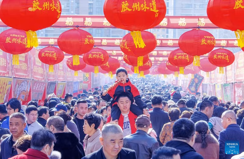 Bé trai ăn kẹo hồ lô tại hội chợ chủ đề hồ lô ở Giao Châu, tỉnh Sơn Đông. am-thuc-truyen-thong-va-xu-huong-moi-bung-no-trong-dip-tet-o-trung-quoc-11.jpg