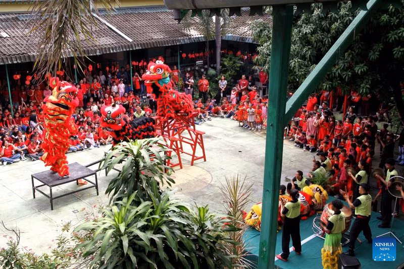 Các em học sinh tiểu học xem màn trình diễn múa lân chào đón Tết Nguyên đán tại Surakarta, Trung Java, Indonesia. khong-khi-don-tet-nguyen-dan-binh-ngo-ron-rang-khap-5-chau-indonesia-2.jpg