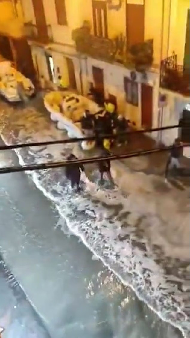 Video trên mạng cho thấy sóng dữ dội nhấn chìm đường, bọt biển dâng tới tầng trệt nhà, người đi bộ phải lội nước để thoát thân trong cảnh hỗn loạn. song-du-doi-nuot-tron-con-pho-khien-dan-thao-chay-2.jpg