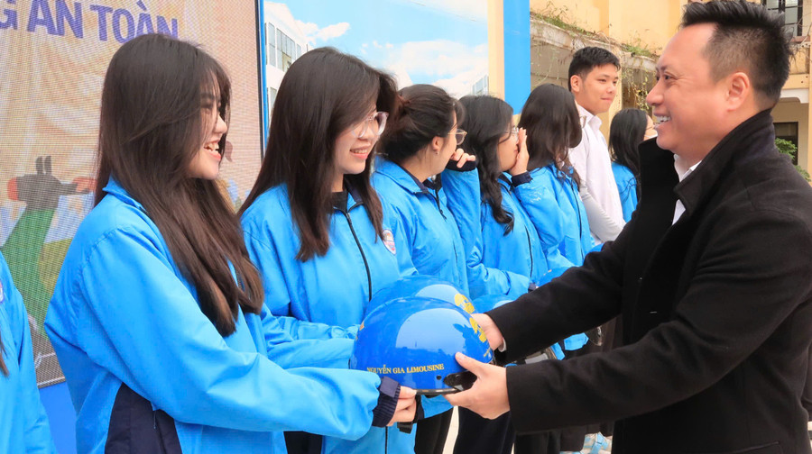 Đại diện nhà tài trợ trao tặng mũ bảo hiểm cho học sinh.
