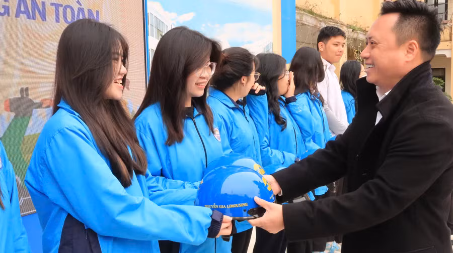 Đại diện nhà tài trợ trao tặng mũ bảo hiểm cho học sinh.